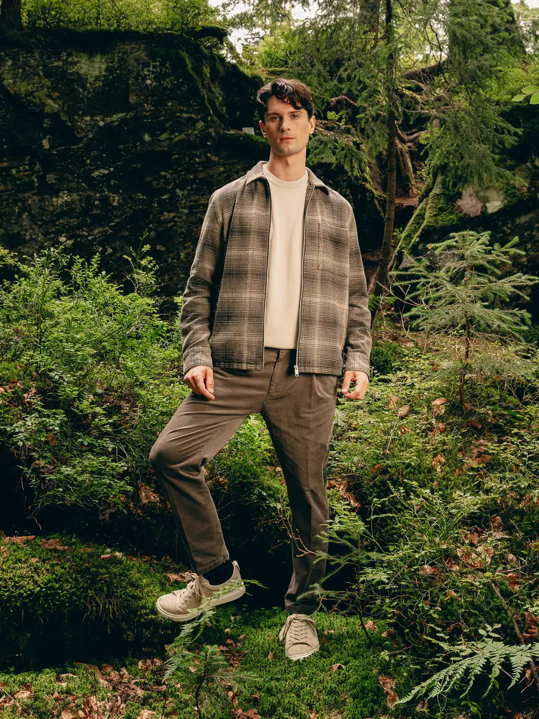 Mann trägt karierte Harrington-Jacke von Marc O'Polo über cremefarbenem Pullover und braune Cordhose – Urban-Heritage-Look Herbst 2026 von FREY Mode