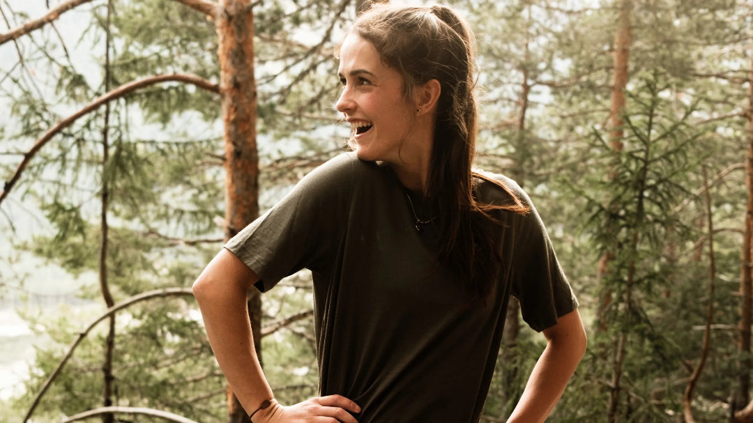 Frau lacht im Wald beim Wandern