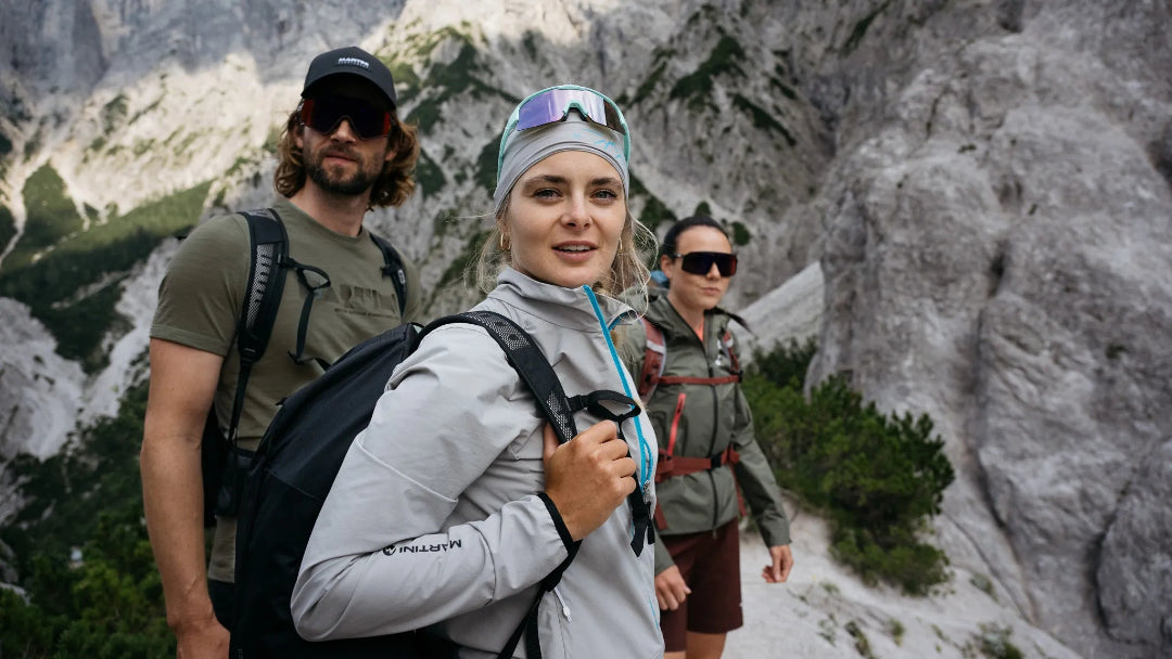 Drei Menschen schauen in die Kamera am Berg