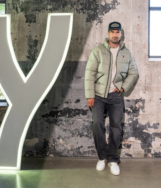 Das Model trägt ein olivfarbenes Outfit.