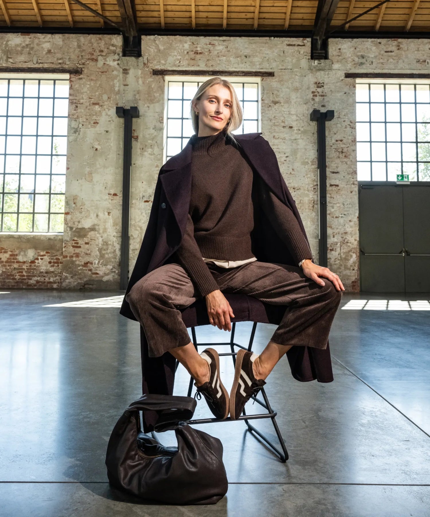 Das Model trägt ein braunes Outfit.